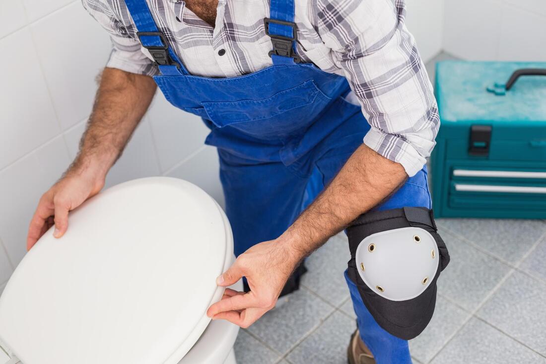 man fixing a toilet